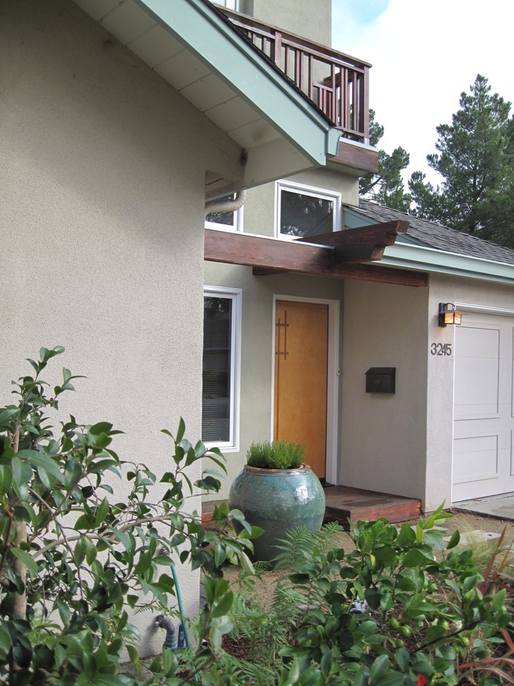 Exemple d'un petit porche d'entrée de maison avant asiatique avec une terrasse en bois et une pergola.