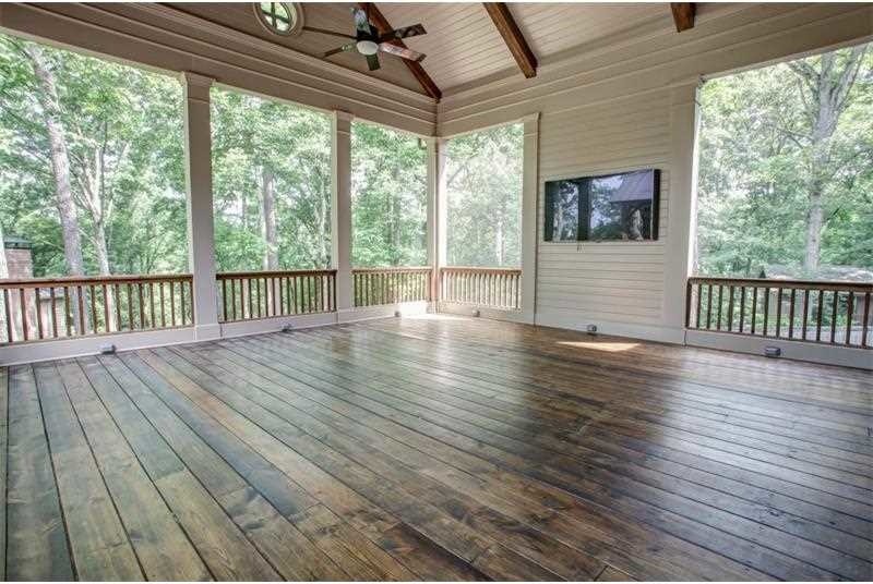 This is an example of a huge craftsman screened-in back porch design in Atlanta with a roof extension.