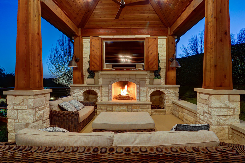 Photo of a large mediterranean back patio in Austin with a fireplace and concrete slabs.