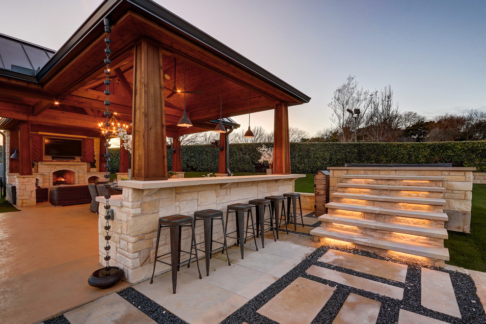 Cette image montre un grand porche d'entrée de maison arrière méditerranéen avec une cuisine d'été et une dalle de béton.