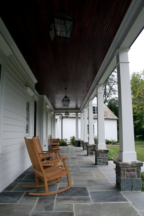 Idéer för en mellanstor klassisk veranda framför huset, med naturstensplattor och takförlängning