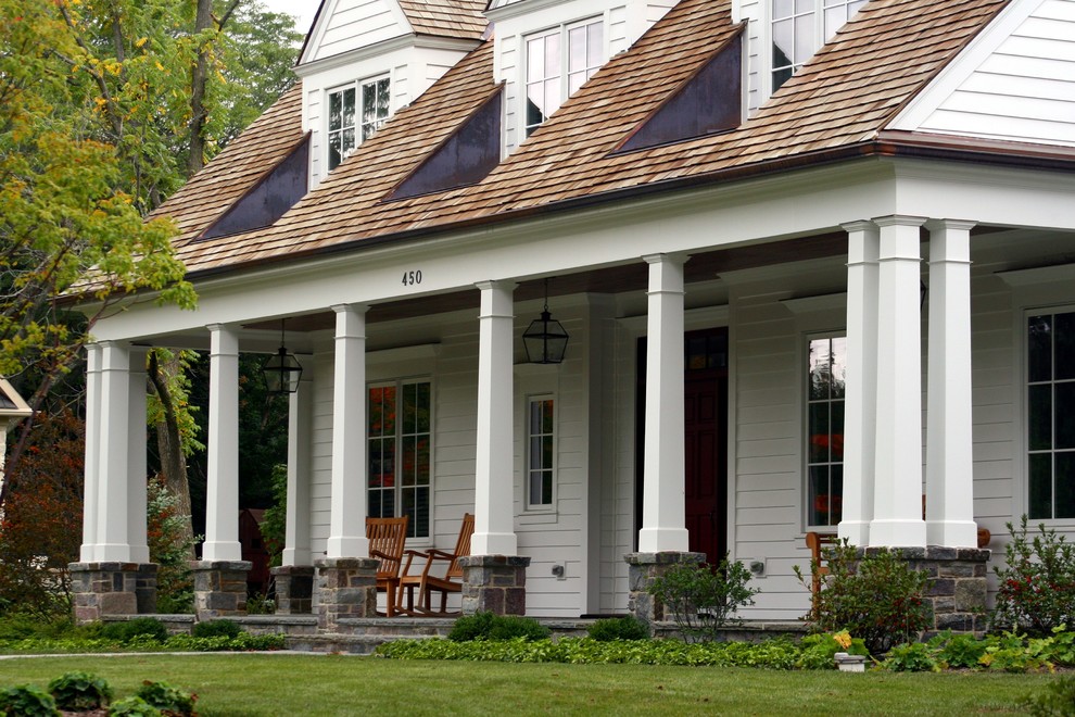 Foto di un grande portico classico davanti casa con un tetto a sbalzo e pavimentazioni in pietra naturale