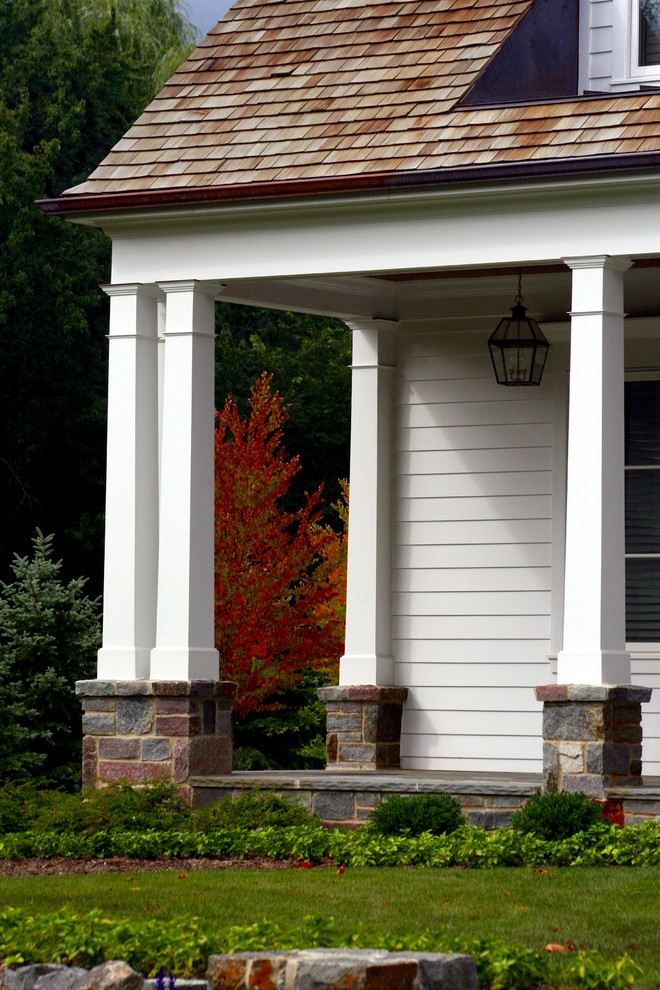 Пример оригинального дизайна: веранда среднего размера на переднем дворе в классическом стиле с навесом и покрытием из каменной брусчатки