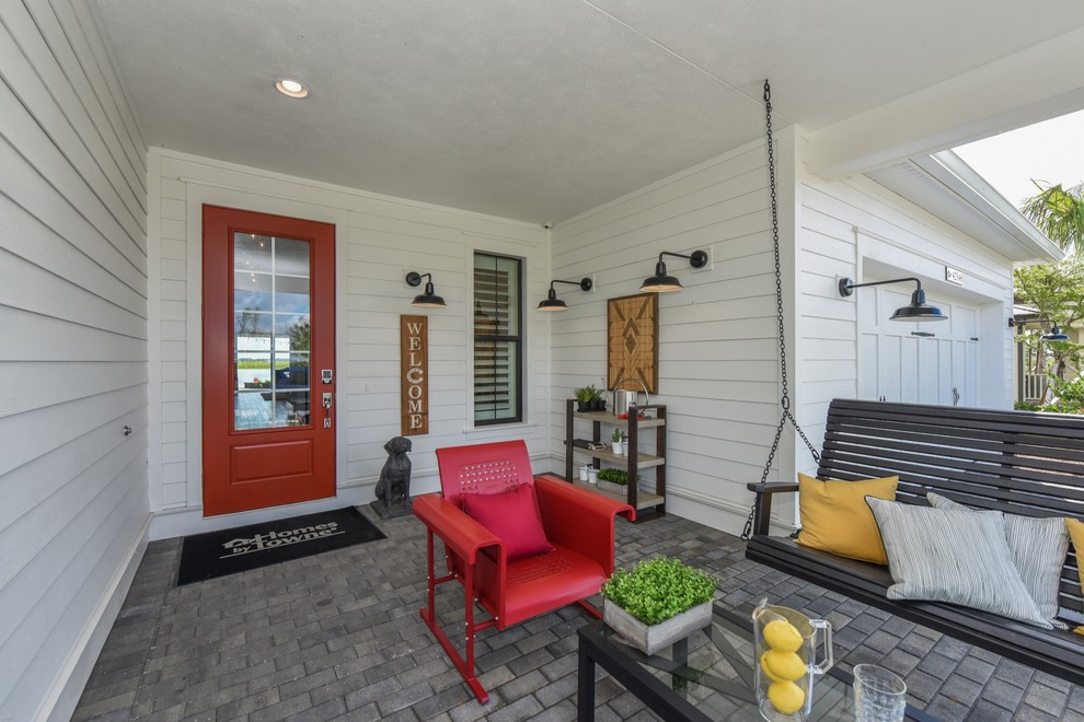 Cottage brick porch photo in Milwaukee with a roof extension