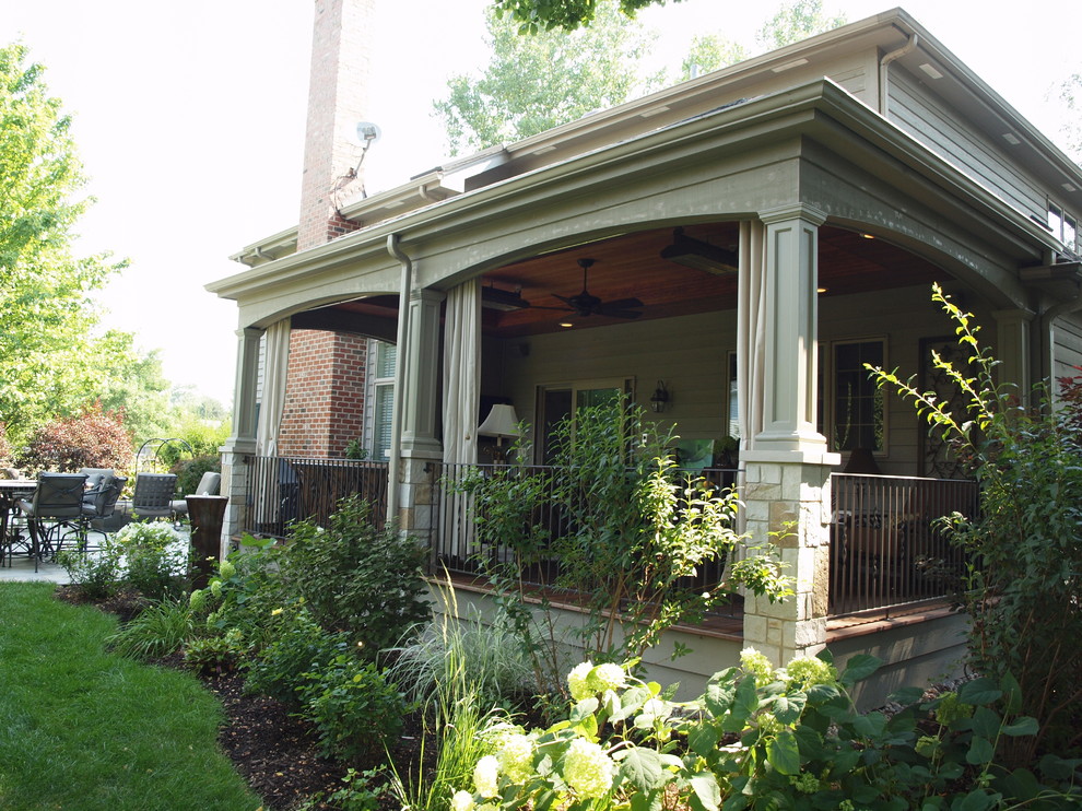 Imagen de terraza tradicional de tamaño medio en patio trasero y anexo de casas con entablado