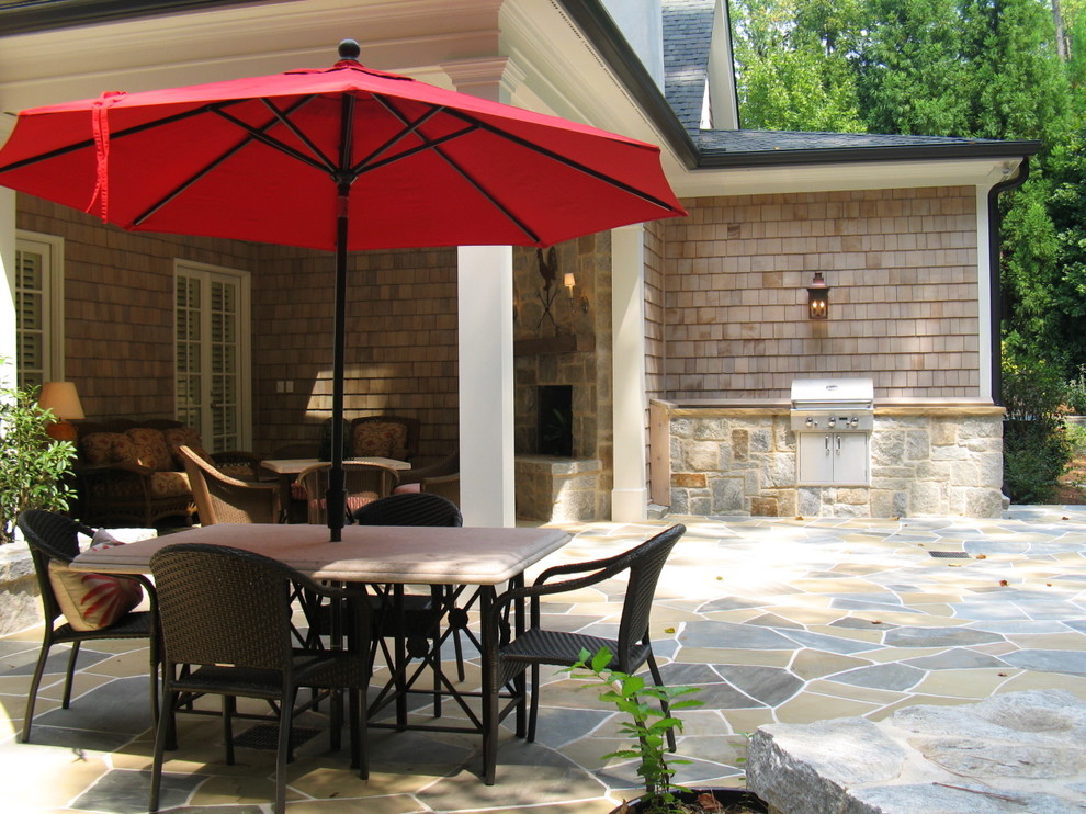 Example of a mid-sized classic stone patio design in Atlanta with a roof extension