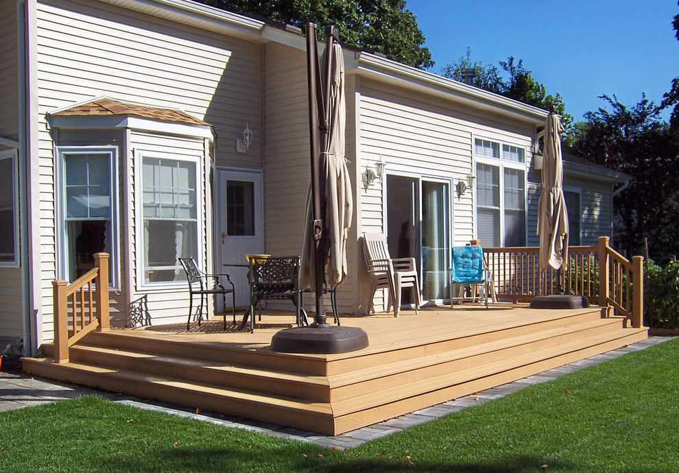 Cette photo montre un petit porche d'entrée de maison arrière chic avec une terrasse en bois.