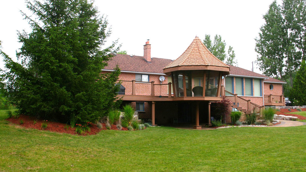 Idéer för stora vintage innätade verandor på baksidan av huset, med trädäck och takförlängning