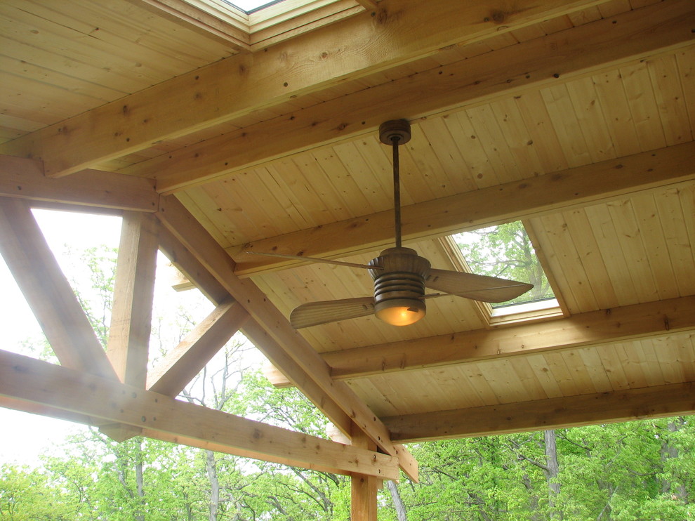 This is an example of a large rustic back porch design in Detroit with a roof extension.