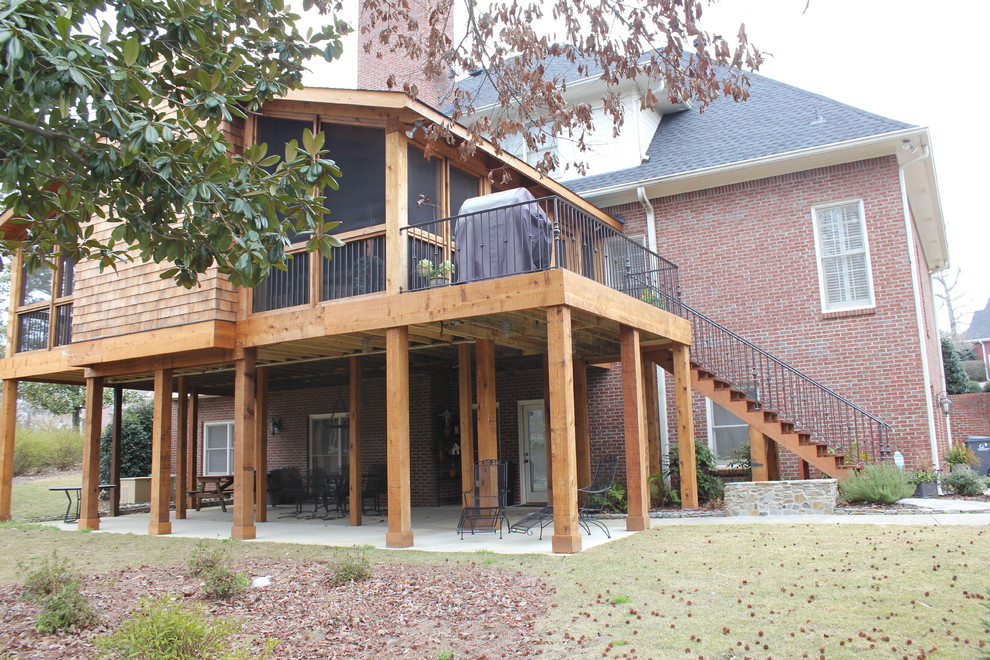 Cette image montre un porche d'entrée de maison arrière traditionnel de taille moyenne avec une terrasse en bois, une extension de toiture et une moustiquaire.