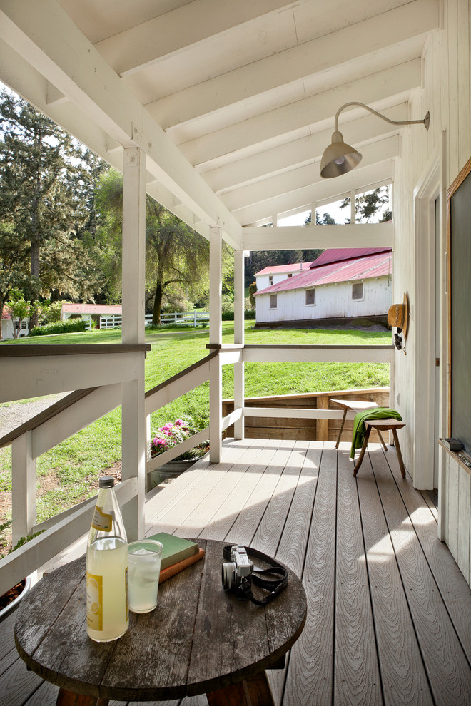 Inspiration pour un porche d'entrée de maison rustique avec une terrasse en bois et une extension de toiture.