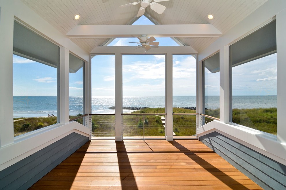 Inspiration pour un grand porche d'entrée de maison avant marin avec une moustiquaire, une terrasse en bois et une extension de toiture.