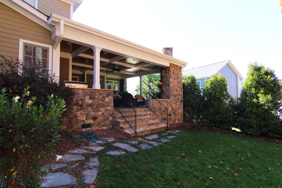 Ejemplo de terraza tradicional grande en patio trasero y anexo de casas con cocina exterior y adoquines de piedra natural