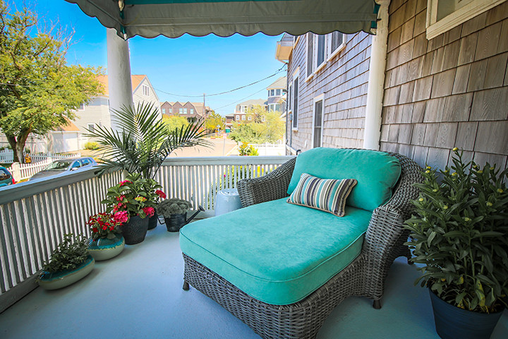 Photo of an expansive nautical front veranda in New York with a roof extension.