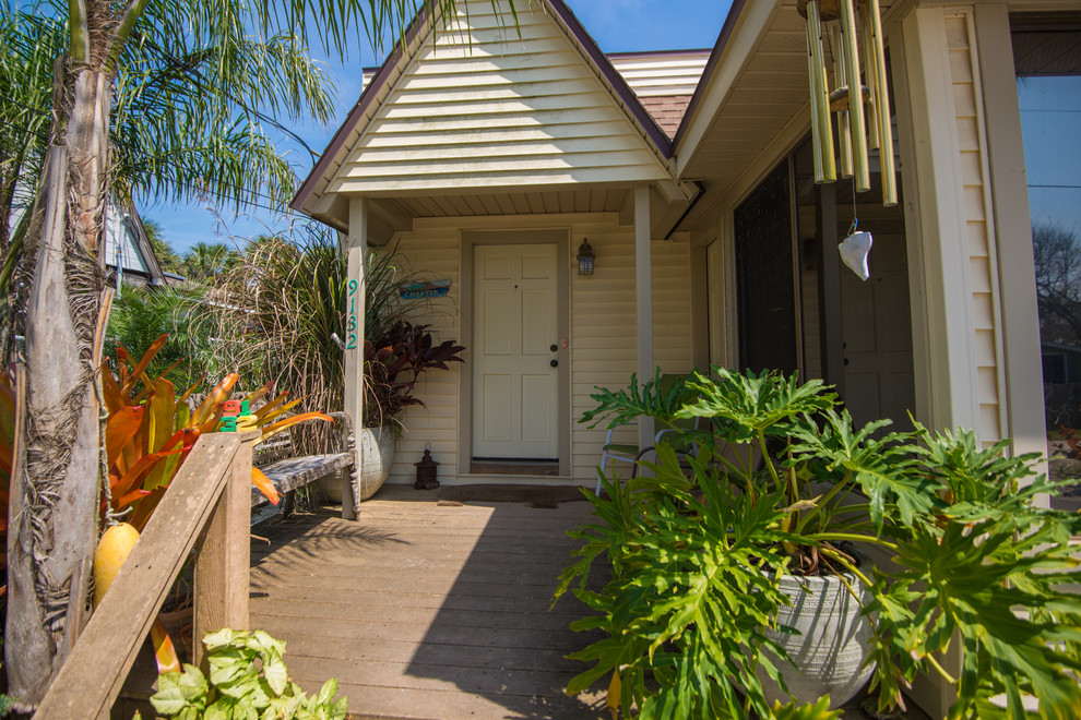 Photo of a small beach style front veranda in Jacksonville with a potted garden, decking and a roof extension.