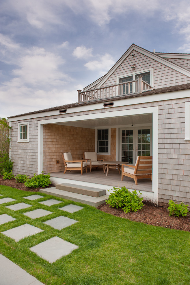 Idées déco pour un porche d'entrée de maison arrière bord de mer avec des pavés en béton et une extension de toiture.