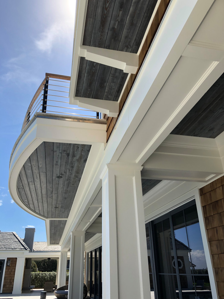 Inspiration pour un très grand porche d'entrée de maison arrière marin avec une extension de toiture.