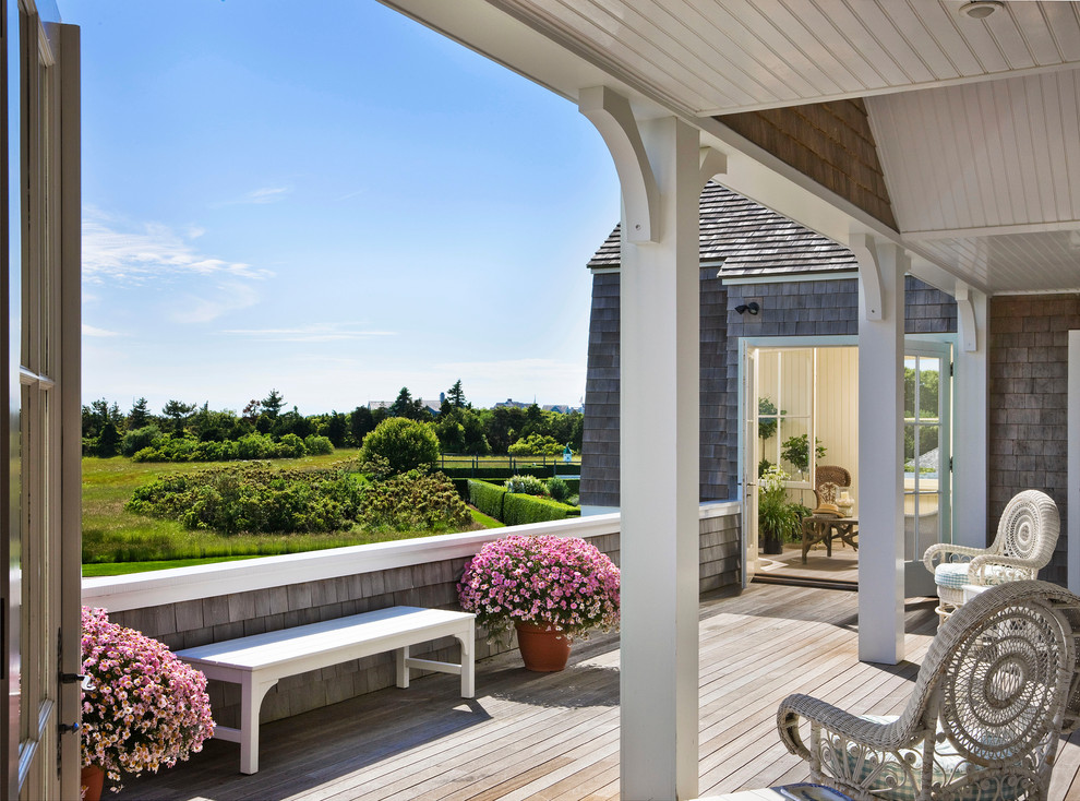 Réalisation d'un grand porche d'entrée de maison arrière marin avec une terrasse en bois et une extension de toiture.