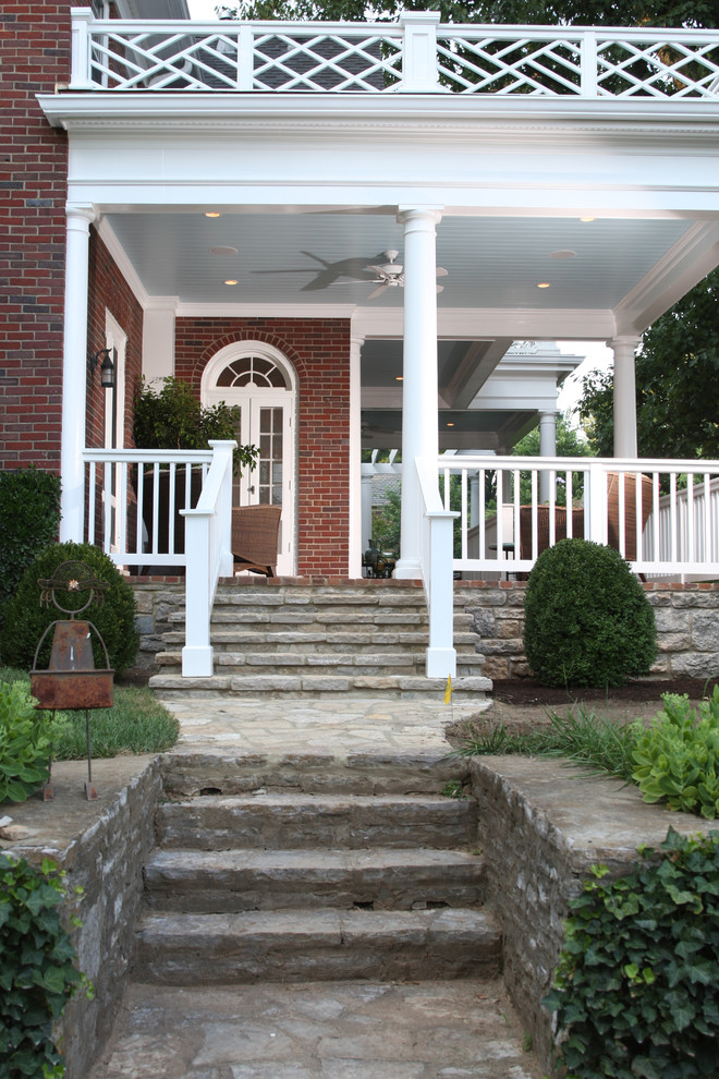 Large classic brick front porch idea in Louisville with a roof extension