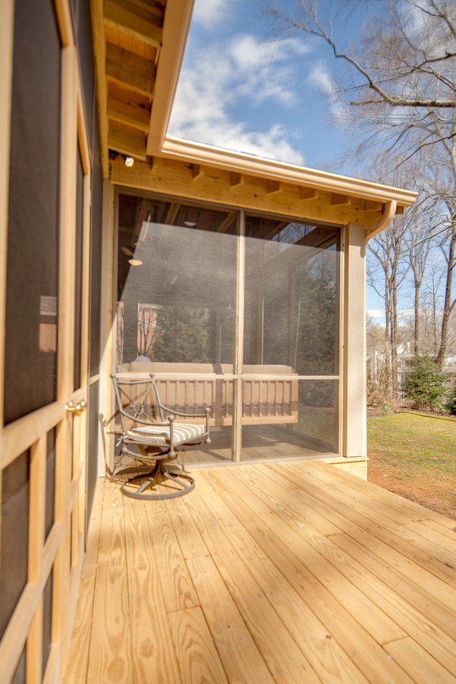 Idée de décoration pour un grand porche d'entrée de maison arrière design avec une moustiquaire, une terrasse en bois et une extension de toiture.