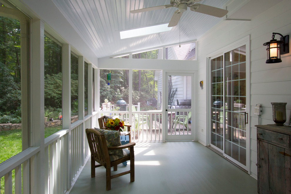 Exemple d'un grand porche d'entrée de maison arrière chic avec une moustiquaire et une terrasse en bois.