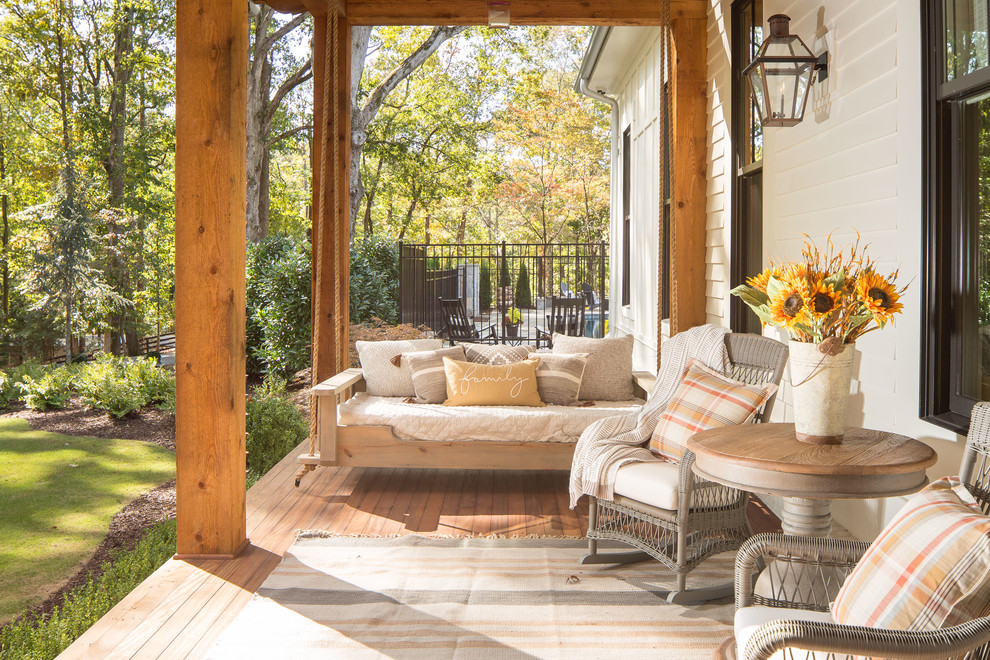 This is an example of a huge farmhouse front porch design in Atlanta with decking and a roof extension.