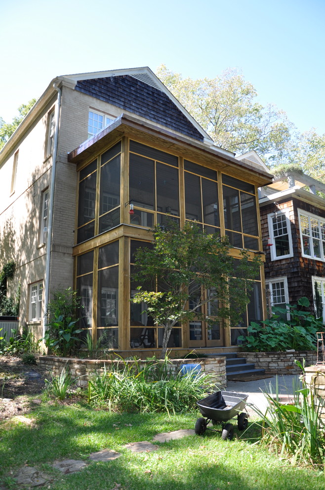 Modern inredning av en mellanstor innätad veranda på baksidan av huset, med naturstensplattor