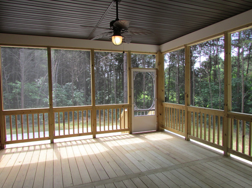 Exemple d'un grand porche d'entrée de maison arrière montagne avec une moustiquaire, une dalle de béton et une extension de toiture.