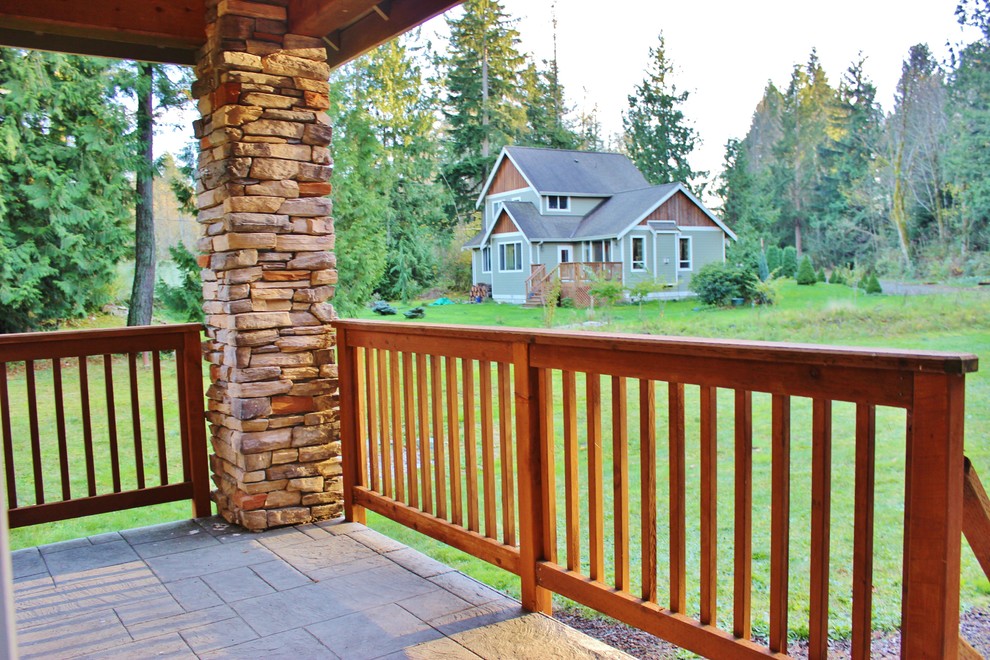 Cette image montre un petit porche d'entrée de maison avant design avec du béton estampé et une extension de toiture.