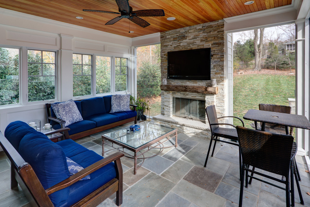 Transitional stone screened-in back porch photo in DC Metro with a roof extension