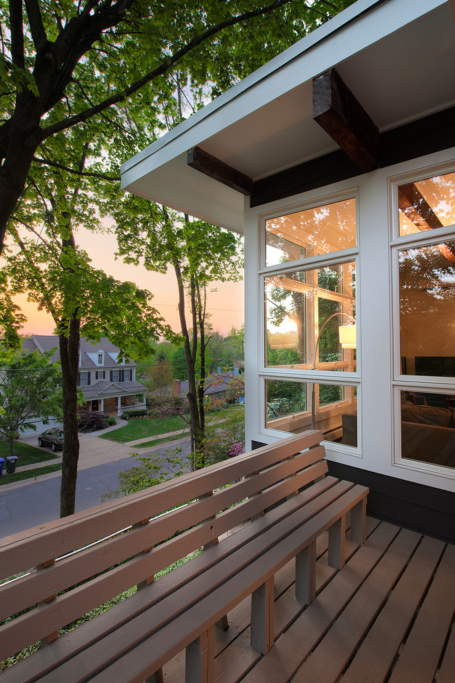 Réalisation d'un porche d'entrée de maison design avec une terrasse en bois.