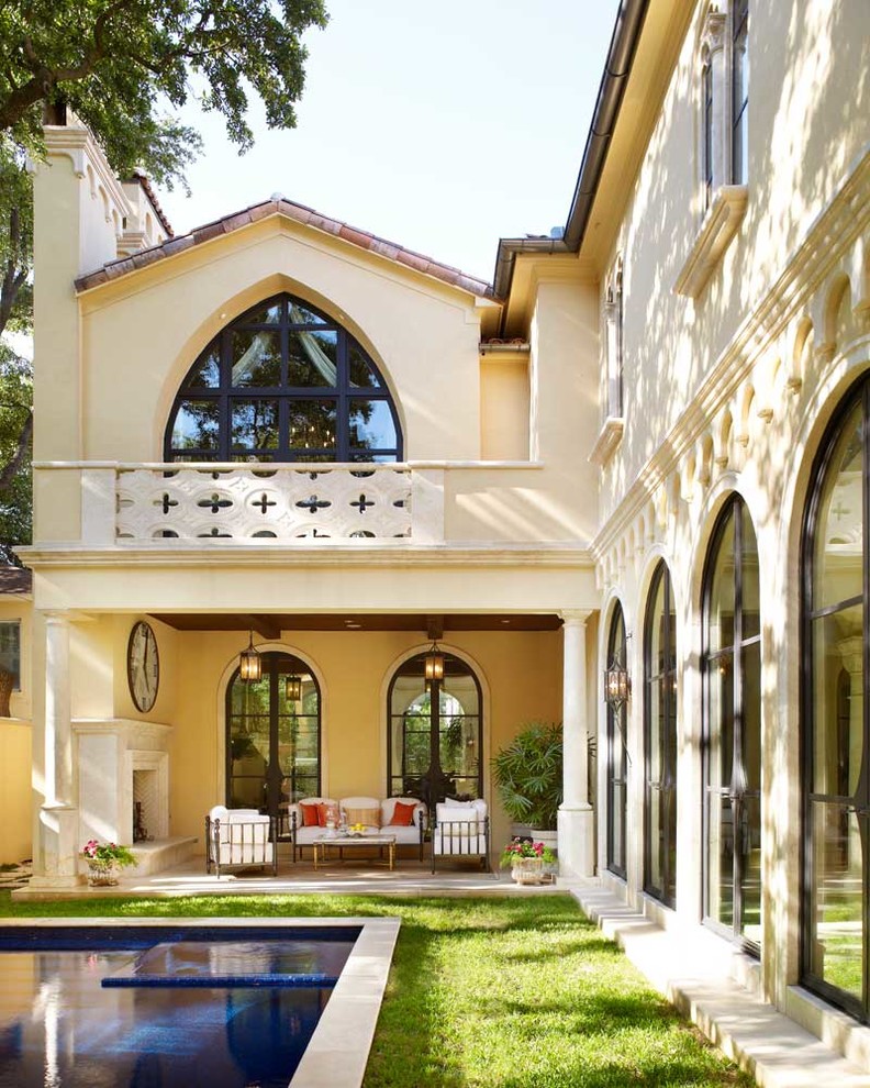 Diseño de terraza mediterránea en patio trasero y anexo de casas con chimenea
