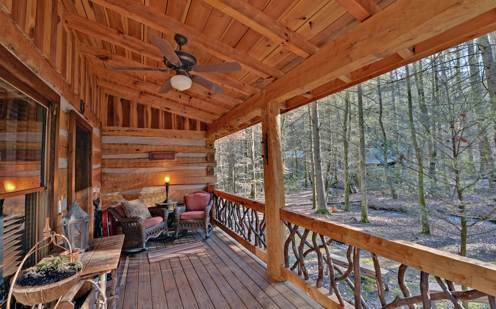 Inspiration pour un porche d'entrée de maison chalet avec une terrasse en bois et une extension de toiture.