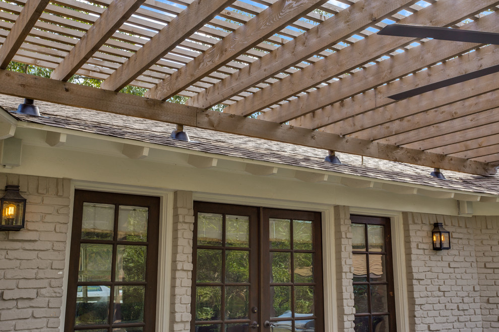 Imagen de terraza tradicional renovada de tamaño medio en patio trasero con cocina exterior, losas de hormigón y pérgola