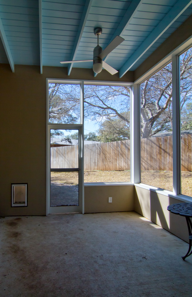 Exemple d'un porche d'entrée de maison arrière tendance avec une moustiquaire et une dalle de béton.