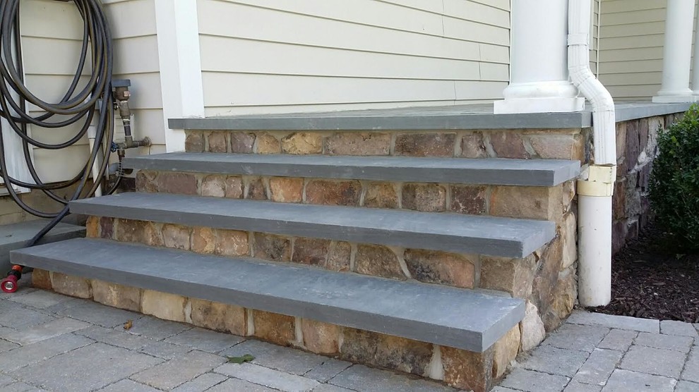Inspiration for a mid-sized timeless stone front porch remodel in New York with a roof extension