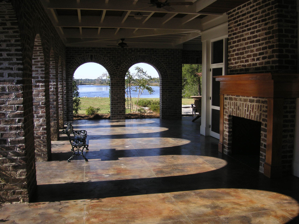 Пример оригинального дизайна: большая веранда в классическом стиле с местом для костра, покрытием из бетонных плит и защитой от солнца