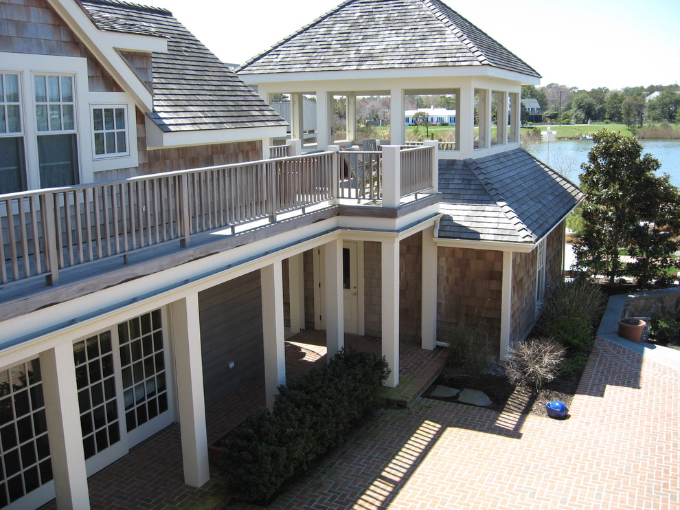 Imagen de terraza costera extra grande en patio lateral y anexo de casas con adoquines de ladrillo