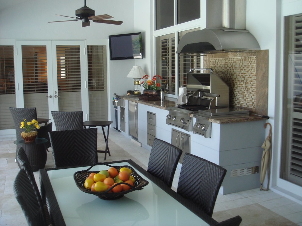 This is an example of a large classic back veranda in Miami with an outdoor kitchen.