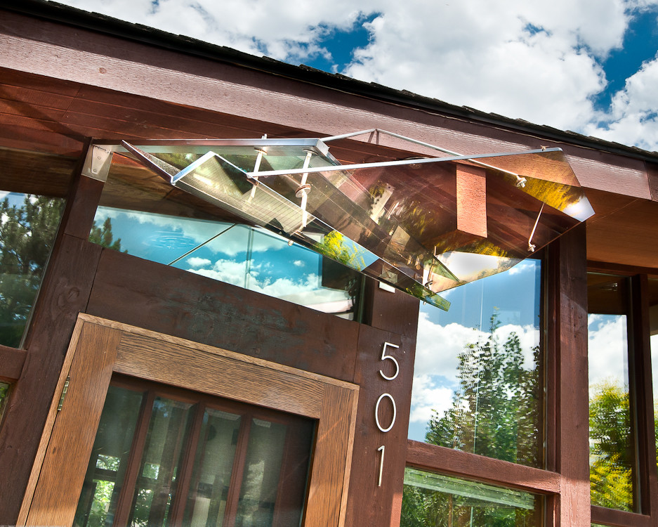 This is an example of a small modern front porch design in Denver with an awning.
