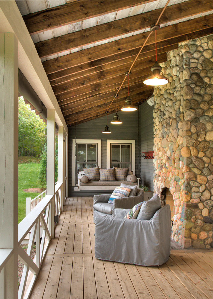 Inspiration for a medium sized rural front veranda in Minneapolis with a fire feature, decking and a roof extension.