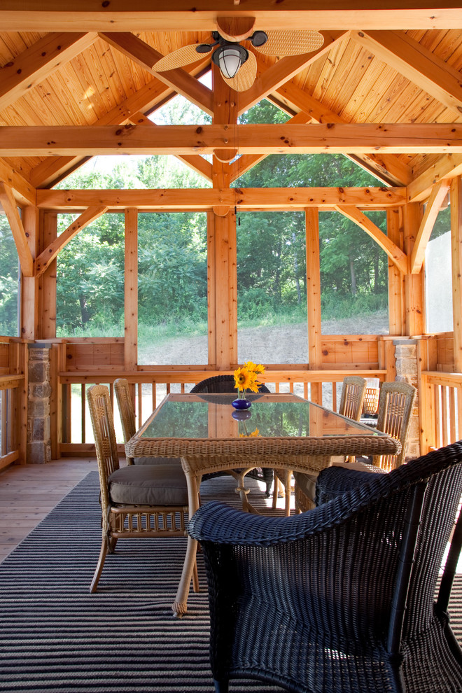This is an example of a rustic screened-in porch design in Baltimore with decking and a roof extension.