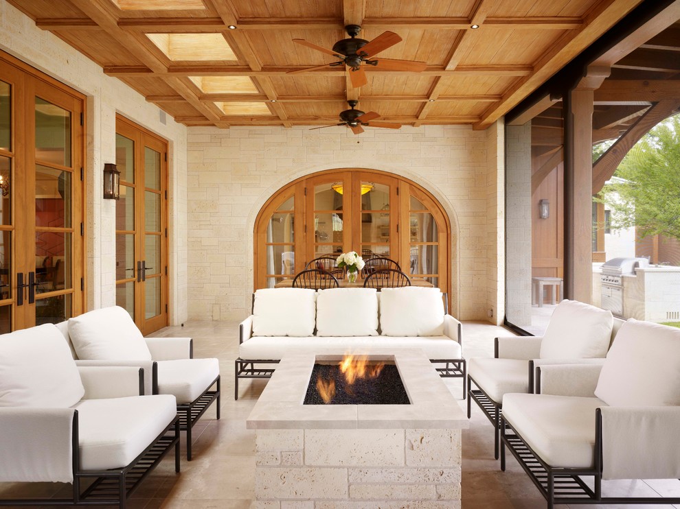 Photo of a mediterranean patio in Austin with a fire feature and a roof extension.