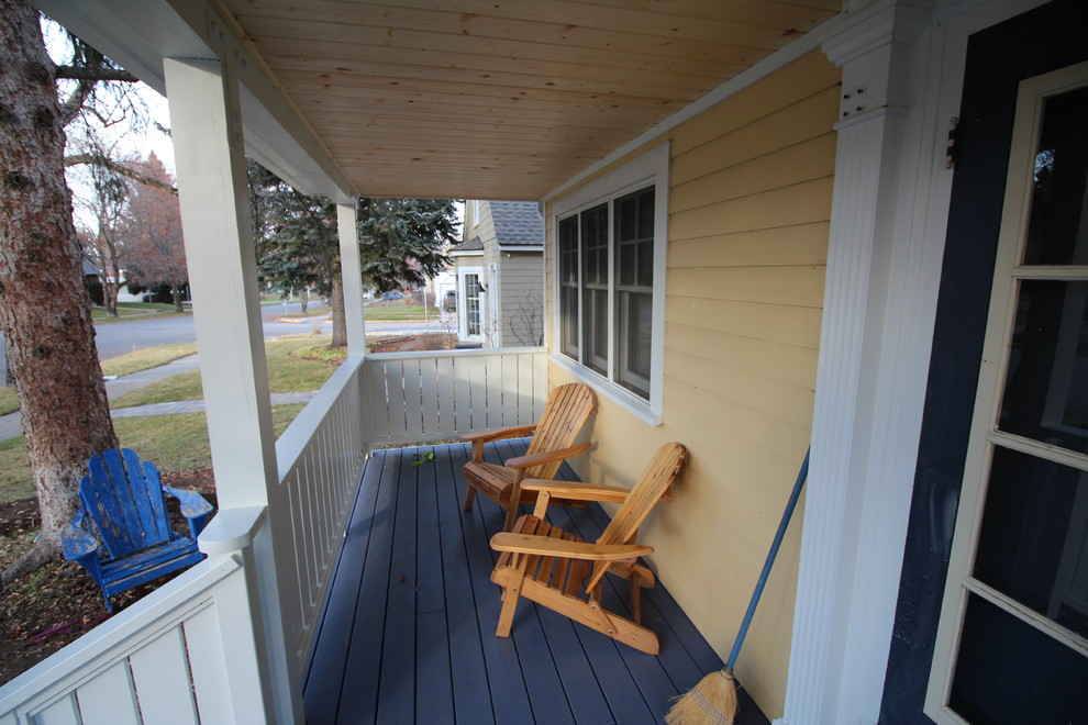 Foto på en mellanstor amerikansk veranda framför huset, med trädäck och takförlängning