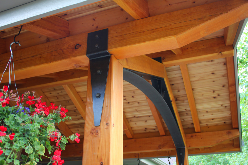 Aménagement d'un porche d'entrée de maison craftsman de taille moyenne avec des pavés en béton et une extension de toiture.