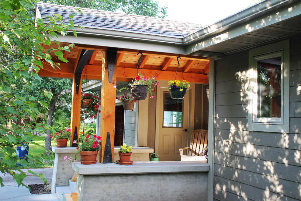 Exemple d'un porche d'entrée de maison craftsman de taille moyenne avec une extension de toiture et une dalle de béton.