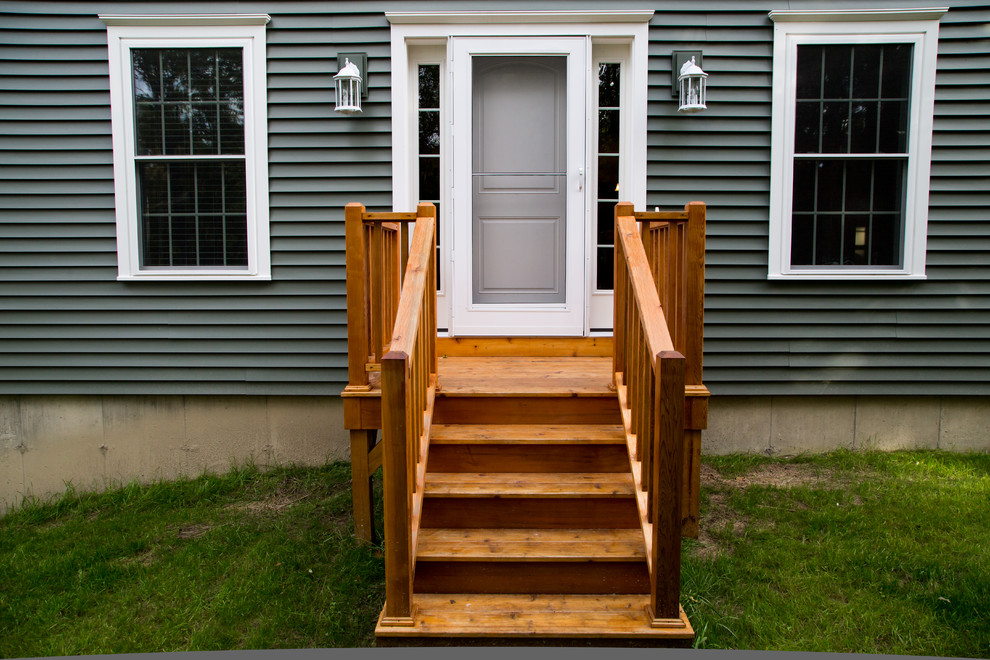 This is an example of a small traditional front porch design in Portland Maine with decking.