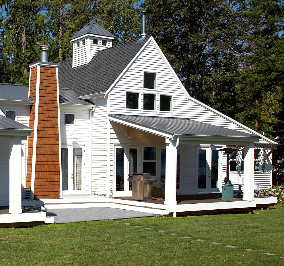 Aménagement d'un porche d'entrée de maison arrière éclectique de taille moyenne avec des colonnes et une extension de toiture.