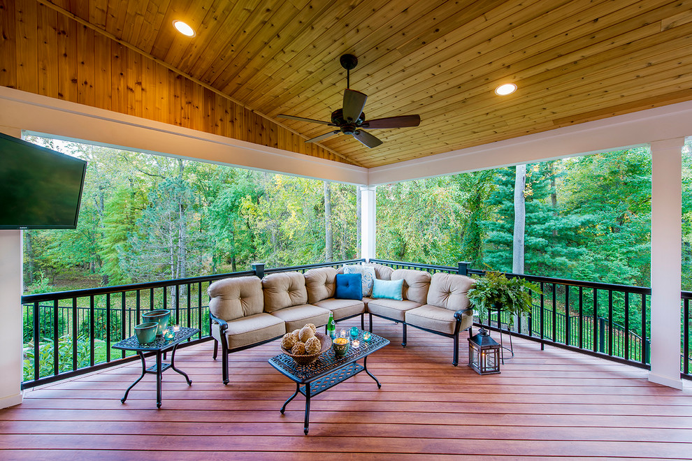 Large classic screened-in back porch idea in Philadelphia with decking and a roof extension