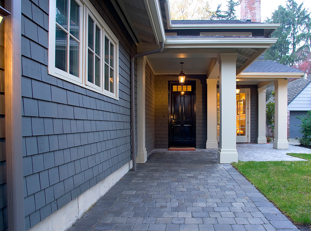 Inspiration for a mid-sized timeless stone front porch remodel in Seattle with a roof extension